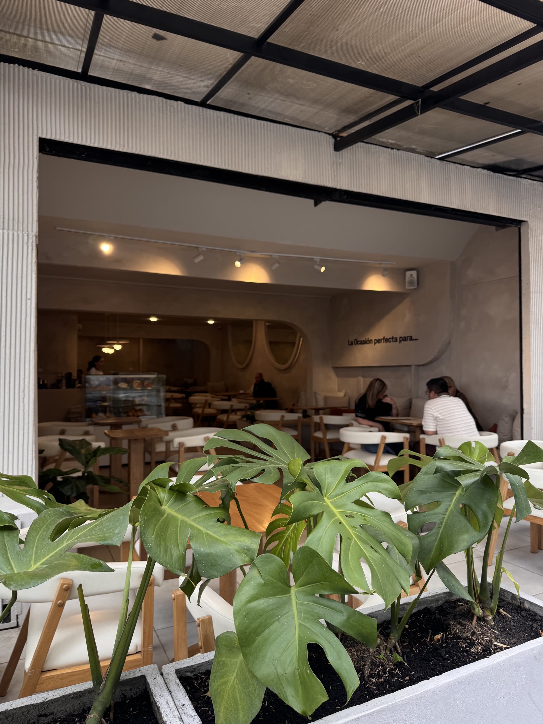 Interior de La Ocasión con plantas y mesas